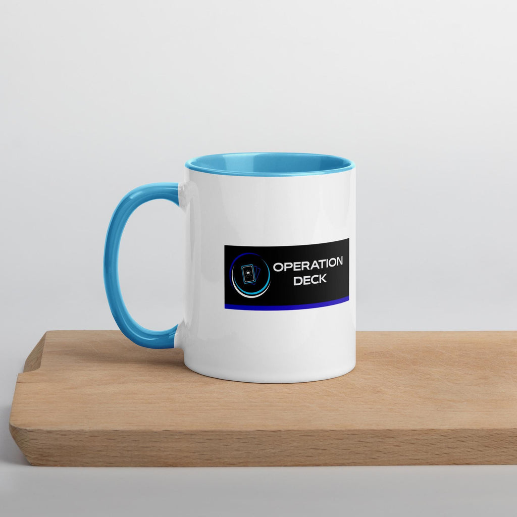 Operation Deck Bien Joué mug logo side on a wooden shelf, cyan handle to the left.