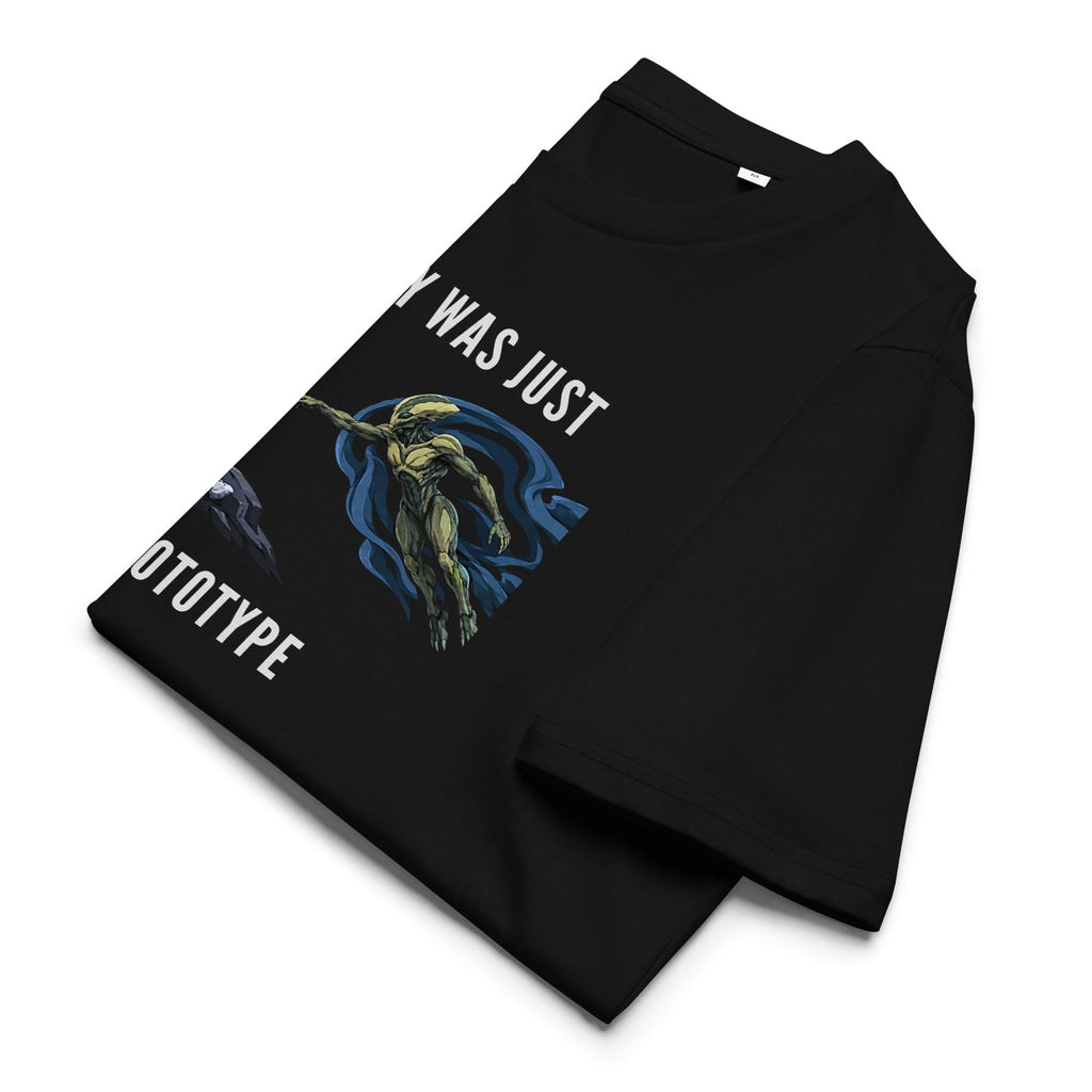 Humanity Prototype AI alien T-shirt in black, folded to show the slogan and creation-style graphic.