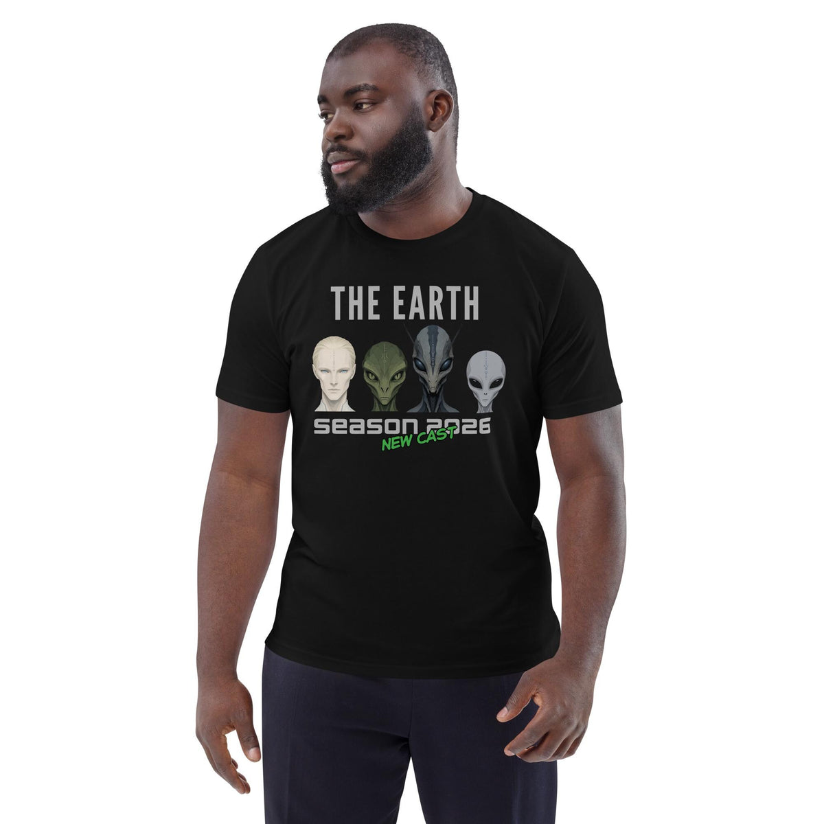 The Earth Season 2026 alien T-shirt in black, worn by a model with dark trousers, three-quarter view.
