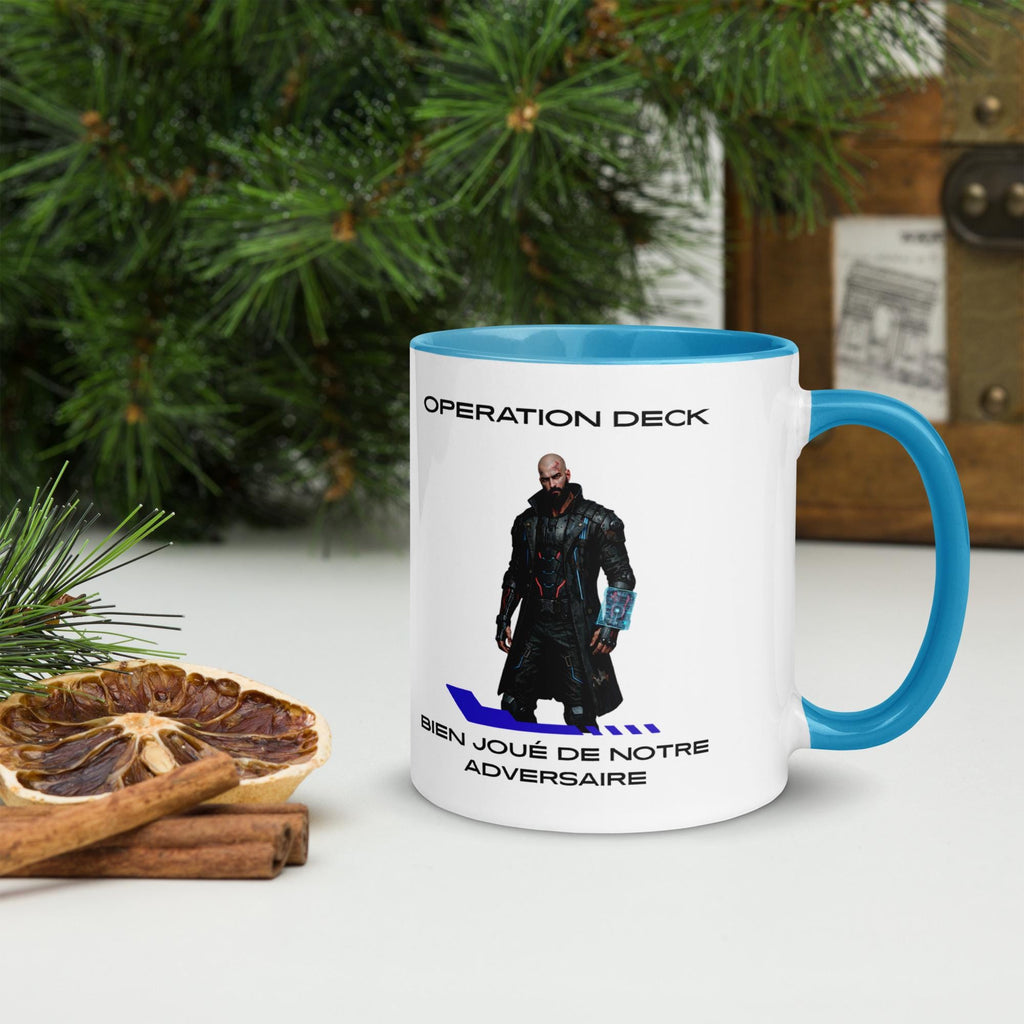 Operation Deck Bien Joué mug character and quote side with a cyan handle beside holiday greenery.