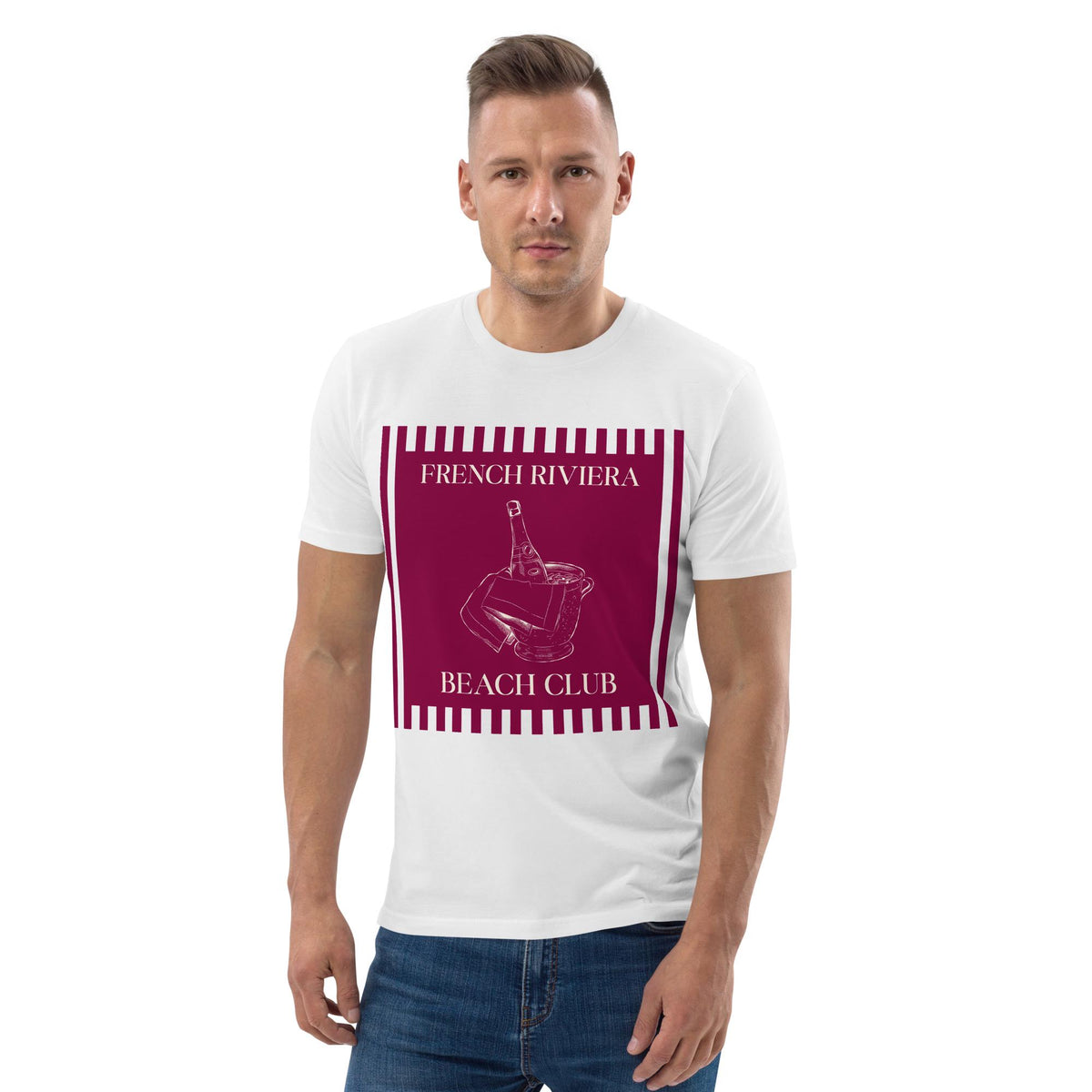 French Riviera Beach Club T-shirt in white, worn by a model with hands in pockets, front view on white.