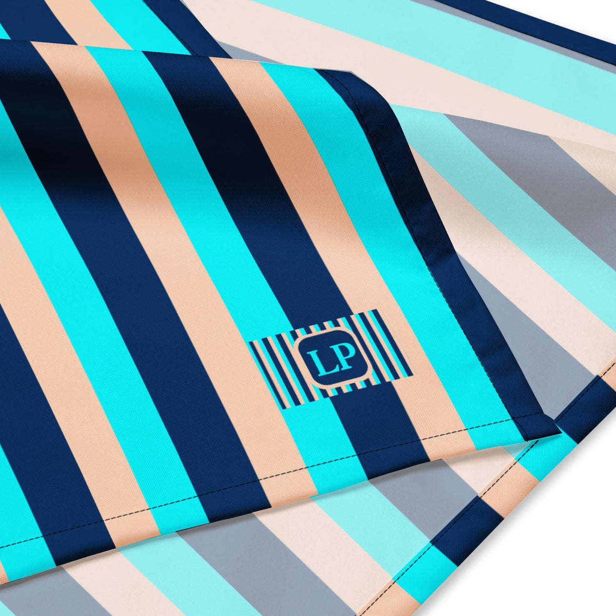 Blue Stripe bandana close-up of the striped fabric, stitched edge and Lagoon Paradox logo.