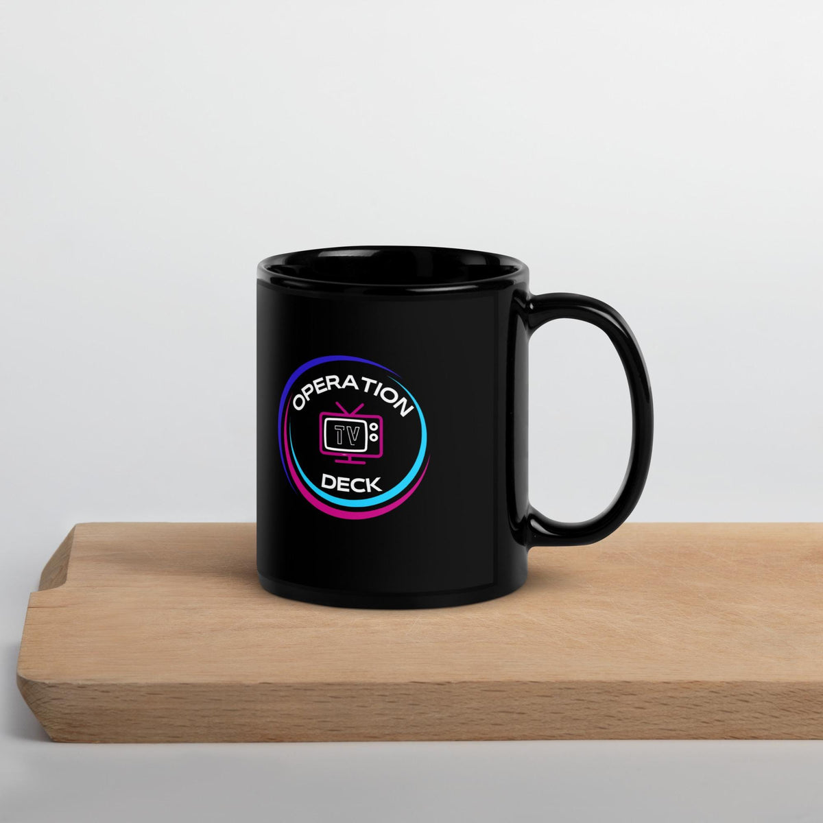 Black Operation Deck gaming mug circular logo side on a wooden shelf.