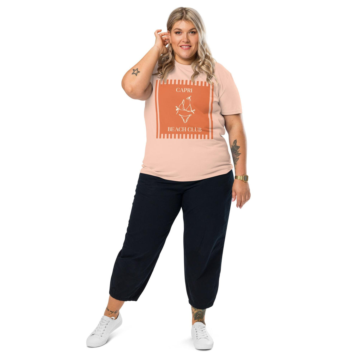 Capri Beach Club T-shirt in peach, full-length view on a model with black trousers.