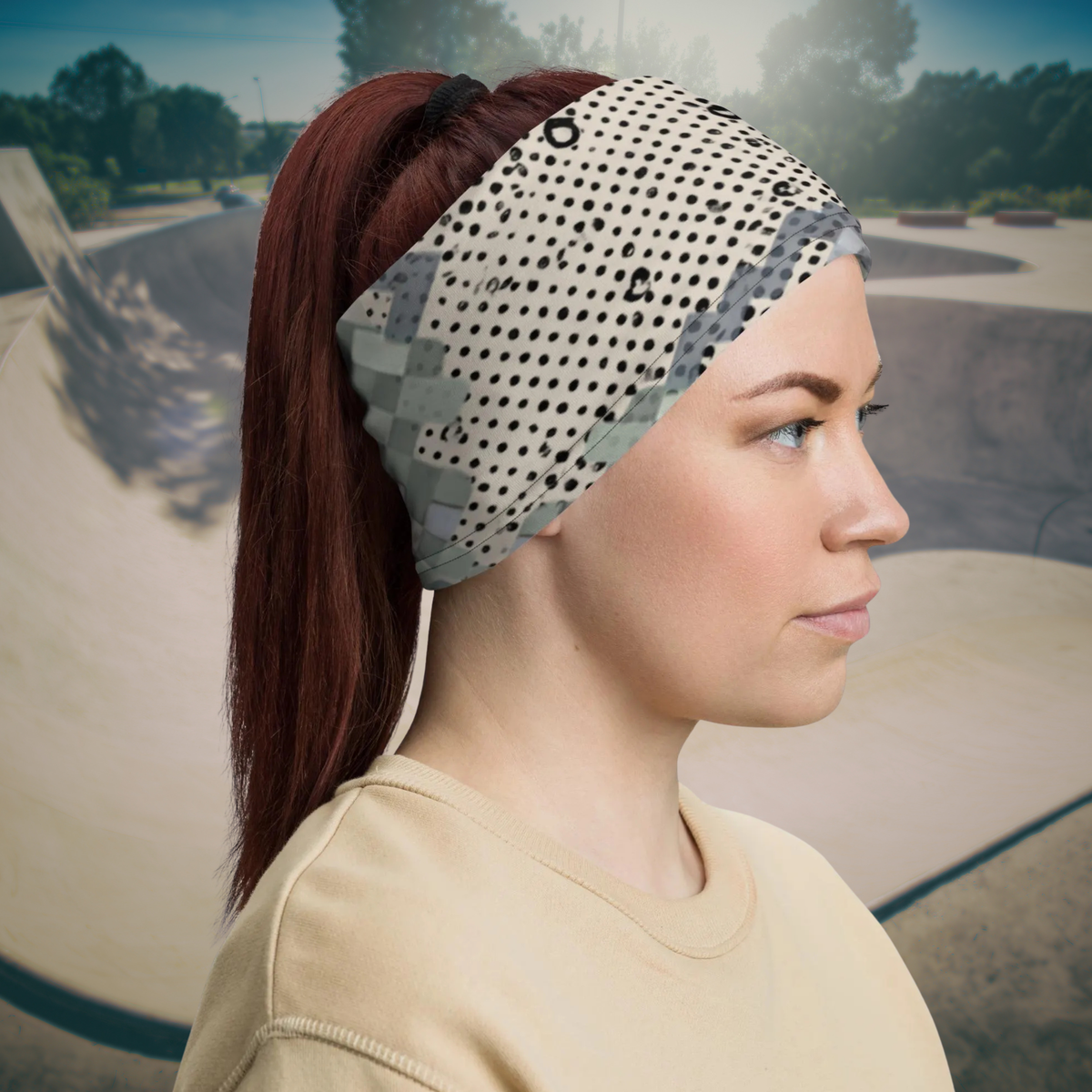 Urban Concrete 9 neck gaiter worn as a headband at a skatepark, side view.