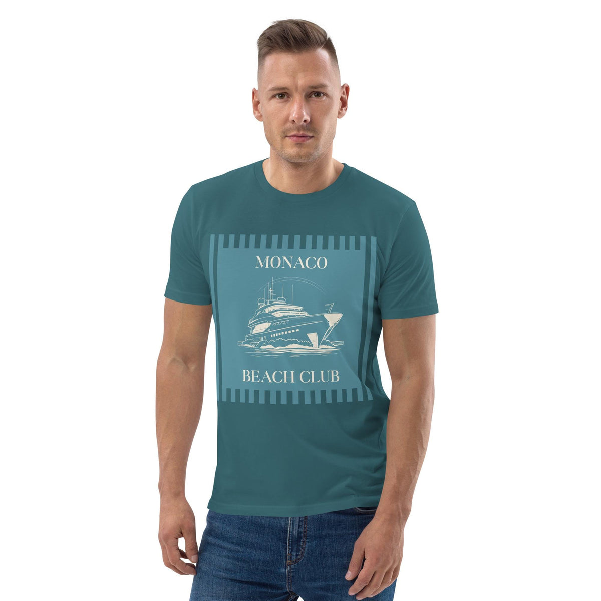 Monaco Beach Club T-shirt in teal, worn by a model with hands in pockets on white.