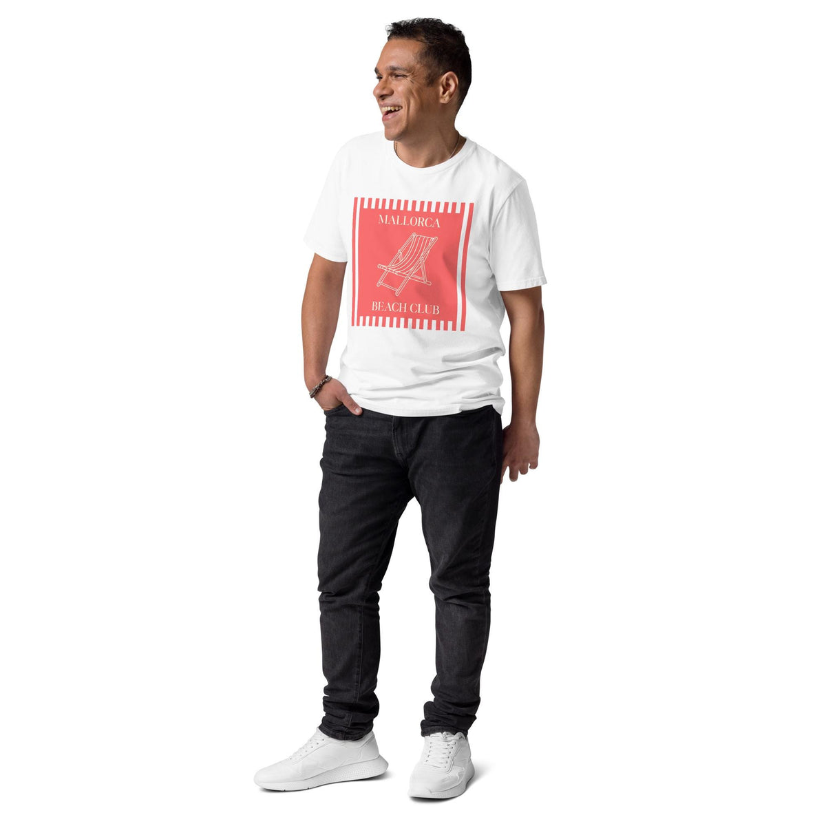 Mallorca Beach Club T-shirt in white, full-length view on a model with hands in pockets.