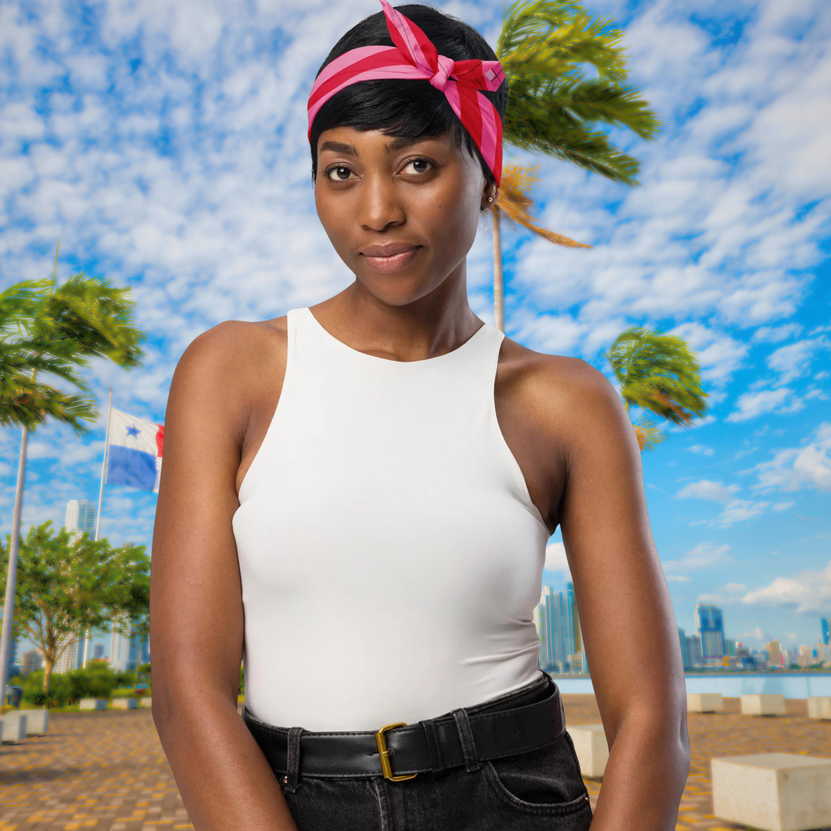 Pink Zebra bandana tied as a headband with a bow beside palm trees.