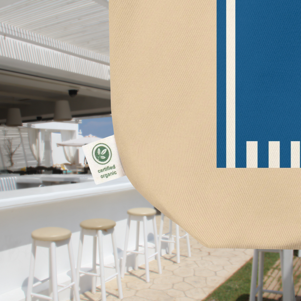 Close-up of the Côte d’Azur tote's cotton fabric, blue striped print and organic cotton label.
