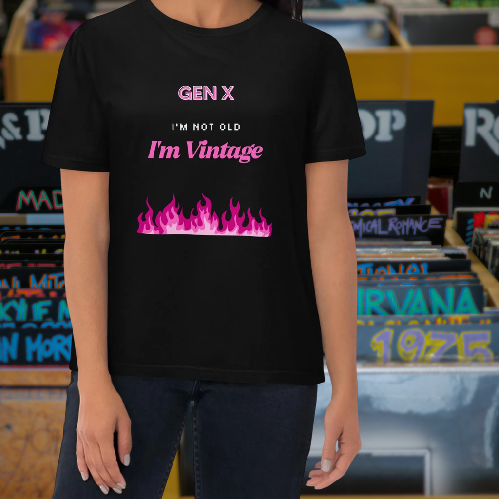 Gen X Pink Flame Vintage T-shirt in black, torso view against a retro music backdrop.