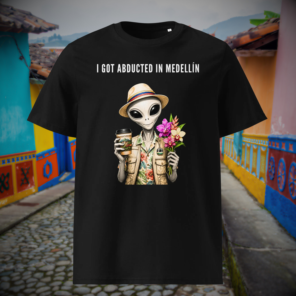 I Got Abducted in Medellin alien T-shirt in black, front product view of the tropical alien against a colorful street.