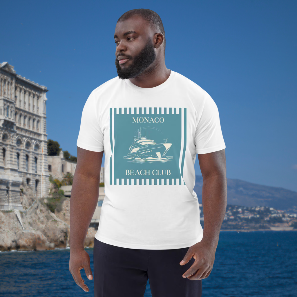 Monaco Beach Club T-shirt in white, worn by a model beside a coastal city backdrop.