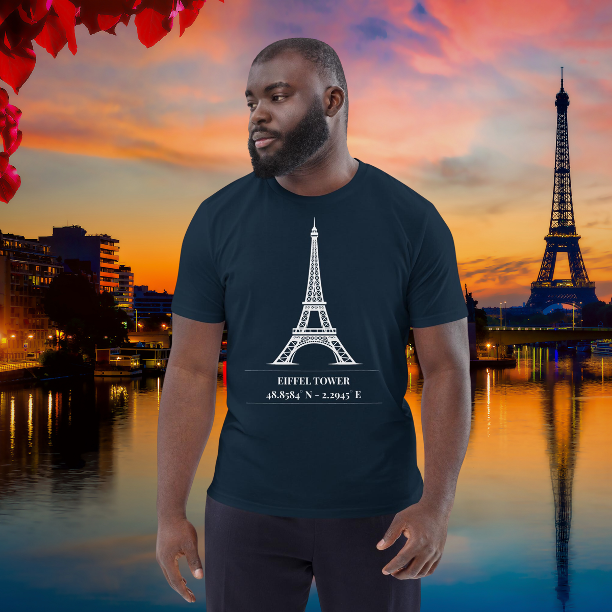 Man wearing the navy Eiffel Tower coordinates T-shirt beside the Seine at sunset.