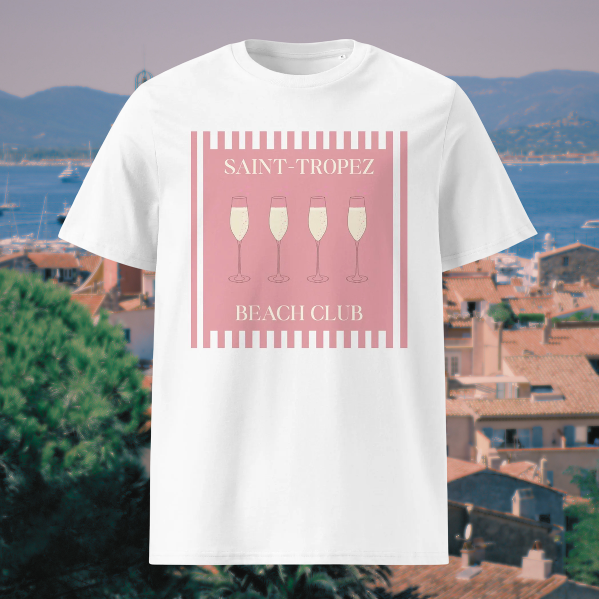 Saint-Tropez Beach Club T-shirt in white, front product view against a coastal town backdrop.
