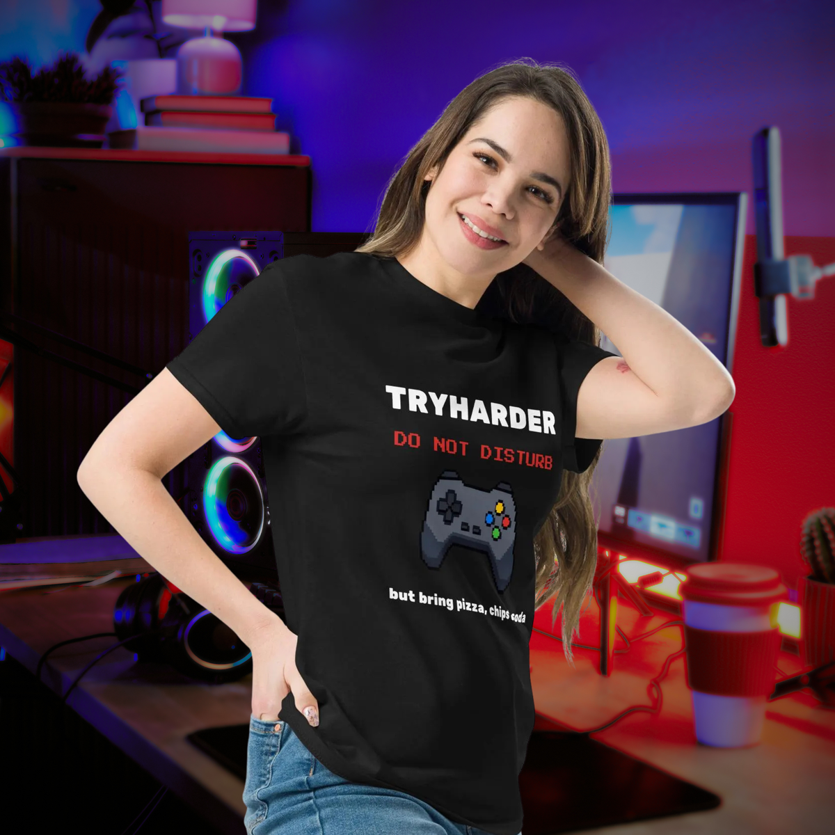 Tryharder gamer T-shirt in black, worn by a model beside headphones and a gaming desk.