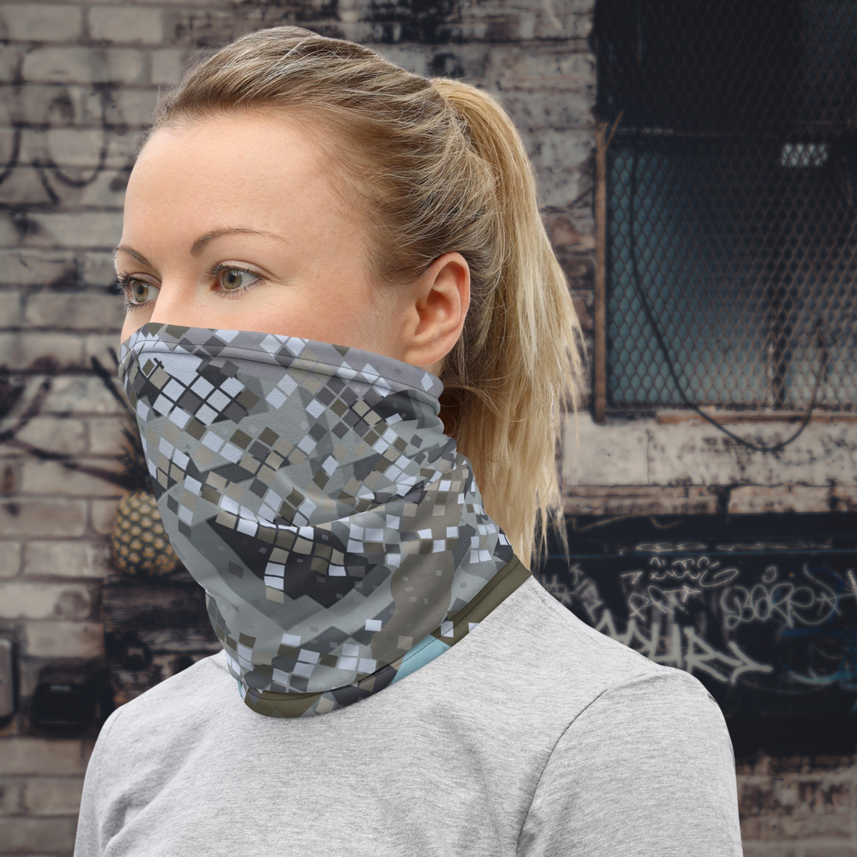 Urban Concrete 2 neck gaiter worn as a face covering against a graffiti-covered wall.