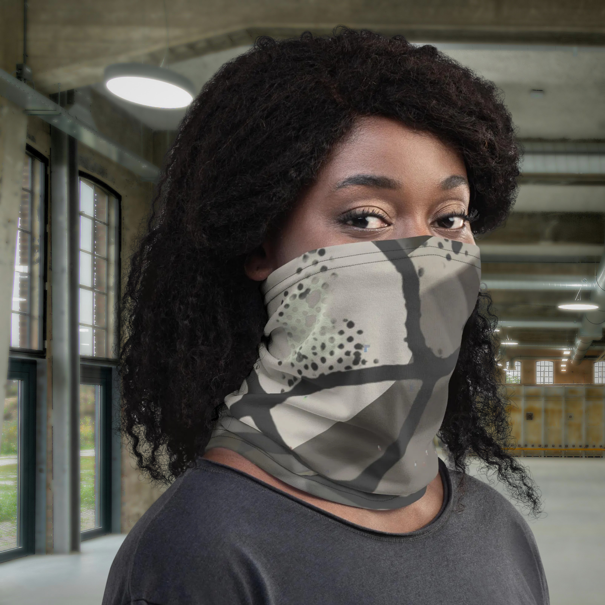 Urban Concrete 5 neck gaiter worn over the nose and mouth in a car park, front view.
