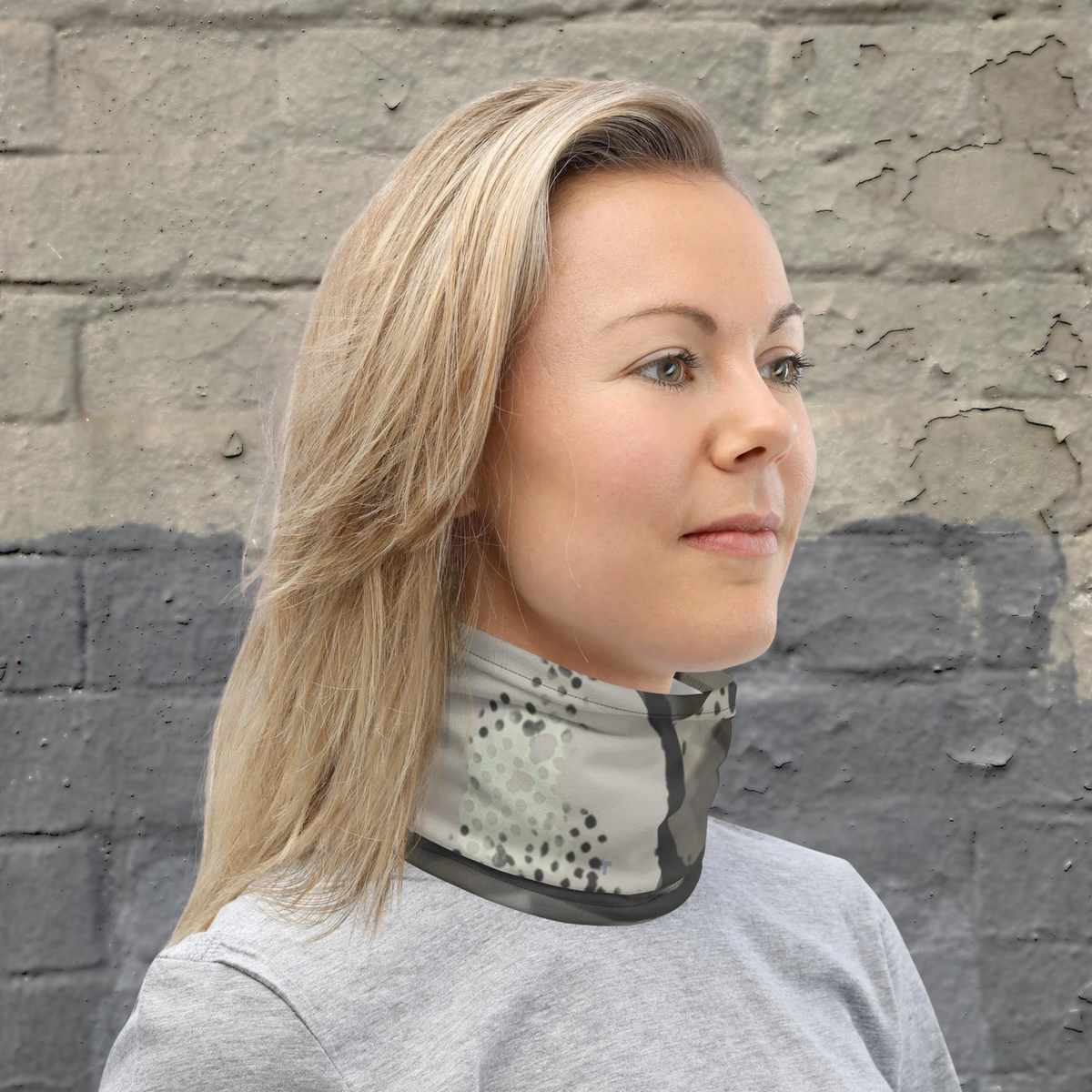 Urban Concrete 5 neck gaiter worn as a neck warmer against a stone wall.