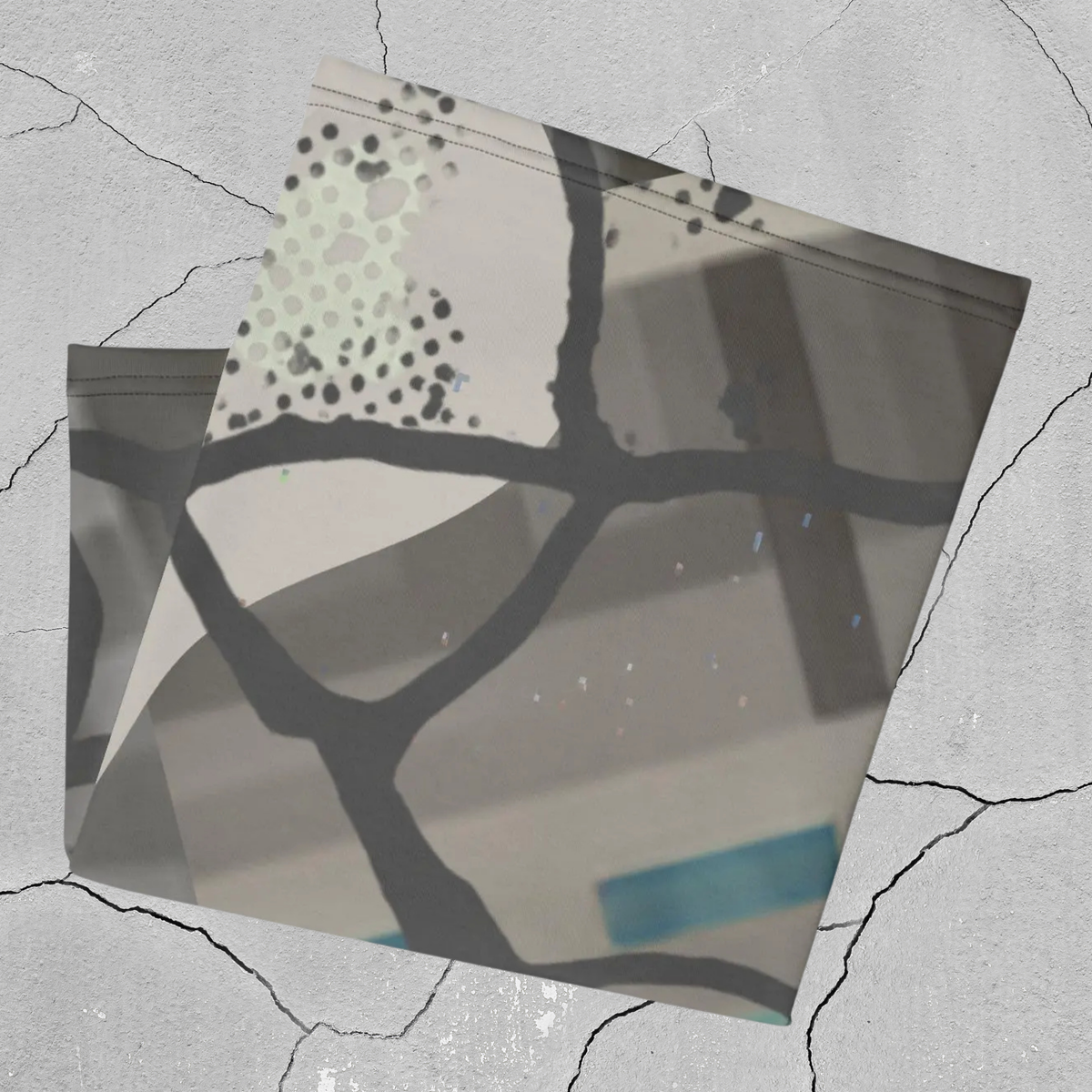 Urban Concrete 5 neck gaiter folded to show grey blocks, black branching shapes and blue accents.