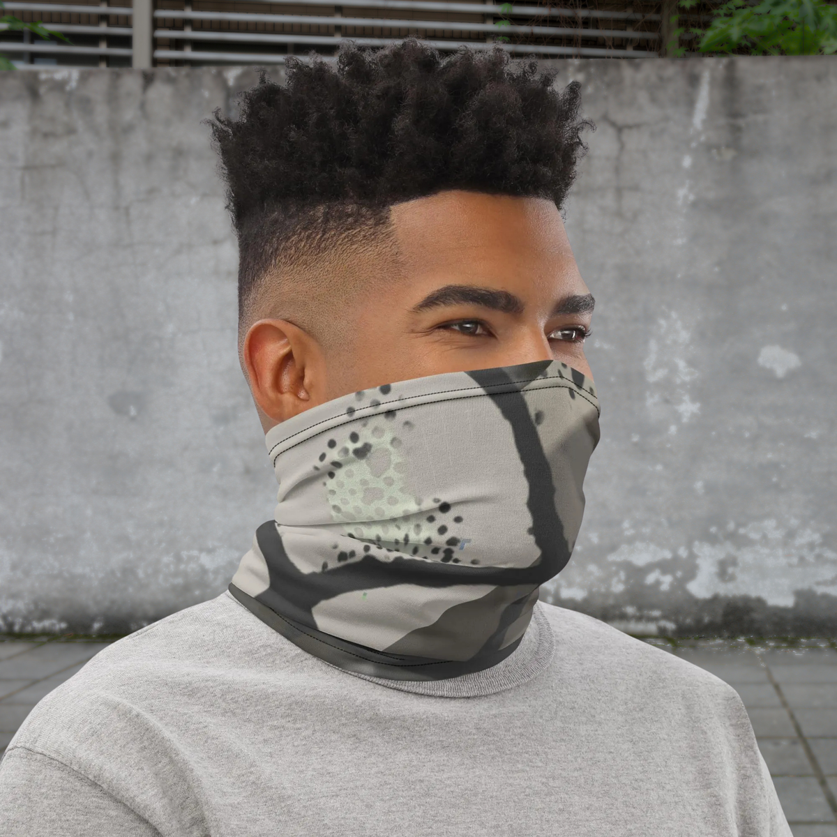 Urban Concrete 5 neck gaiter worn as a face covering against a weathered concrete wall.