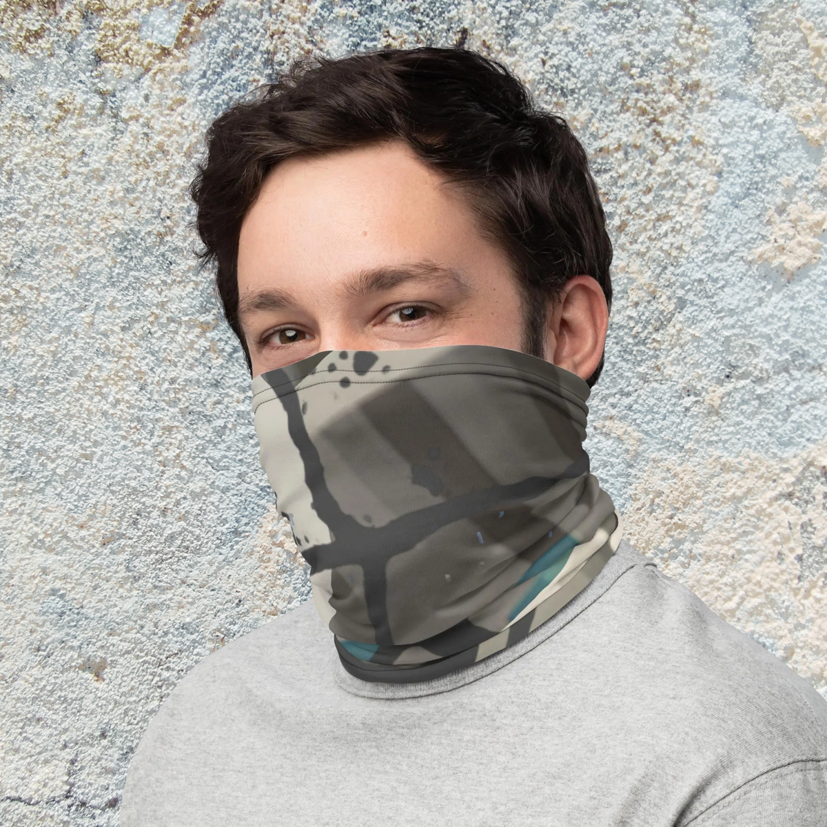 Urban Concrete 5 neck gaiter worn as a face covering against a textured wall, three-quarter view.