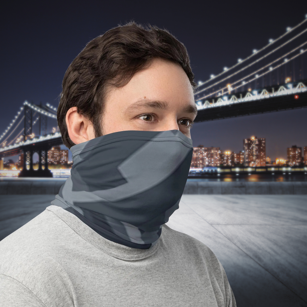 Urban Concrete 8 neck gaiter worn as a face covering beside an illuminated bridge at night.
