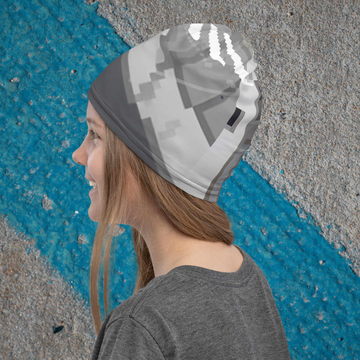 Urban Concrete 10 neck gaiter worn as a beanie, side view against a blue-and-grey wall.
