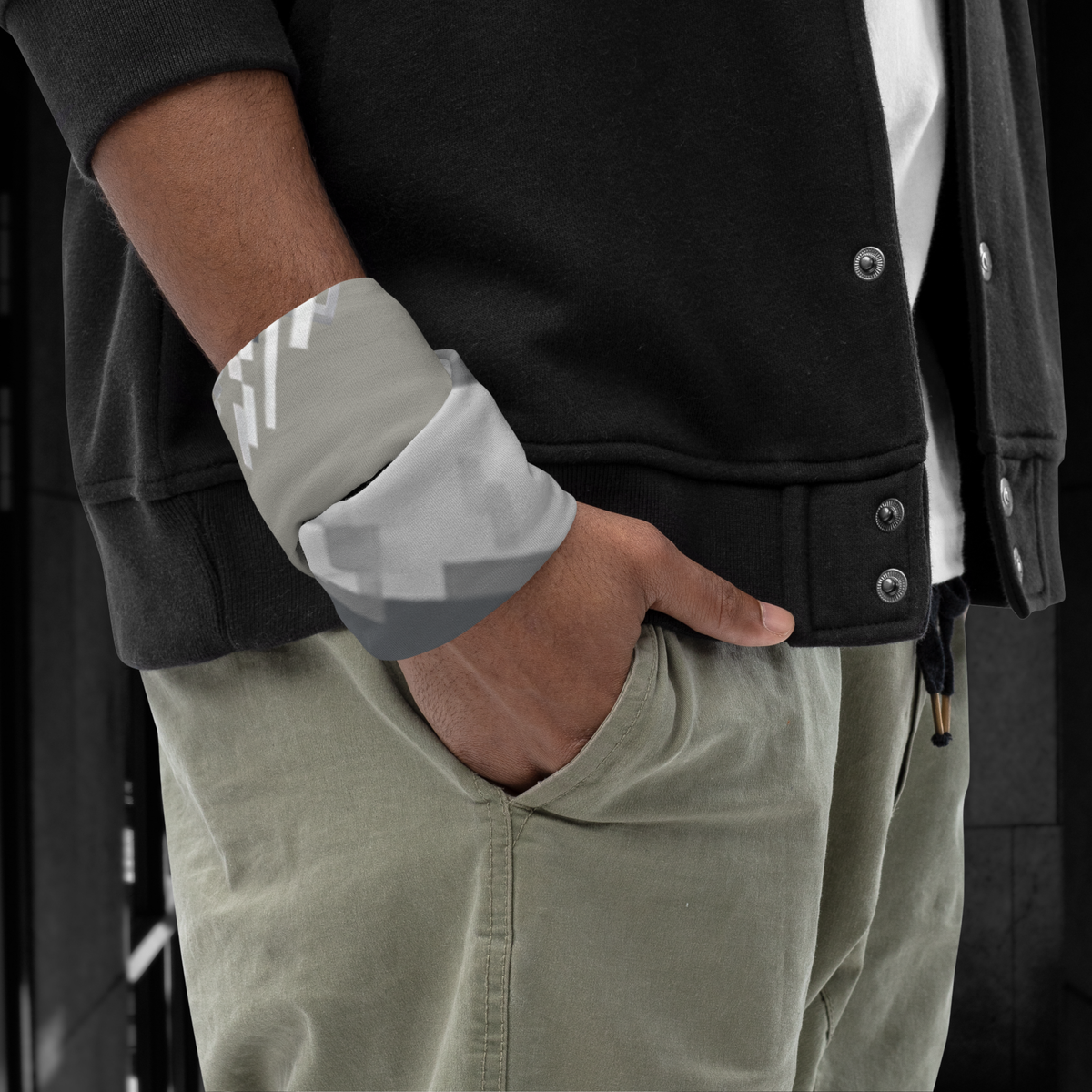 Urban Concrete 10 neck gaiter wrapped around the wrist beside a black jacket.