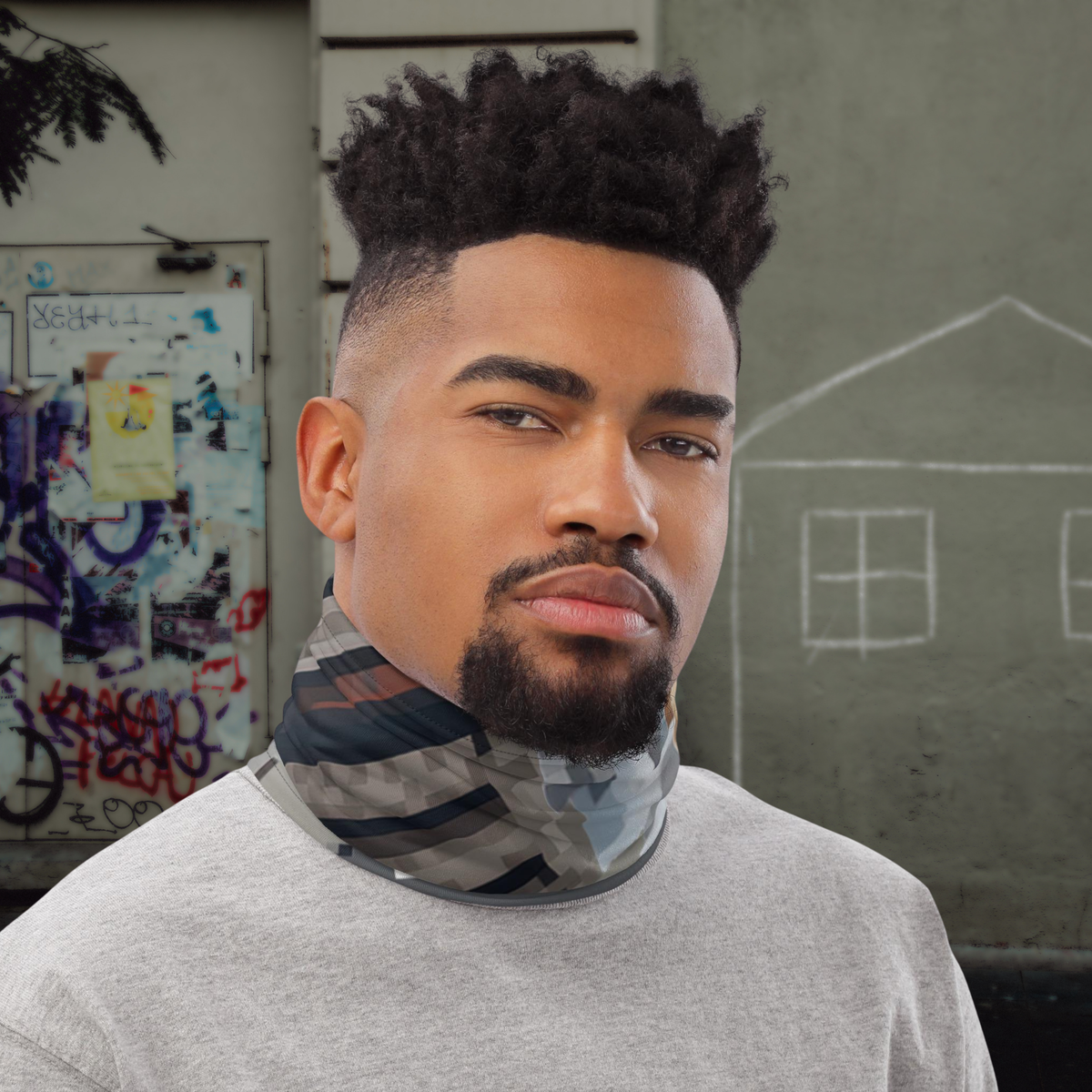 Urban Concrete 10 neck gaiter worn as a neck warmer outside a graffiti-covered building.