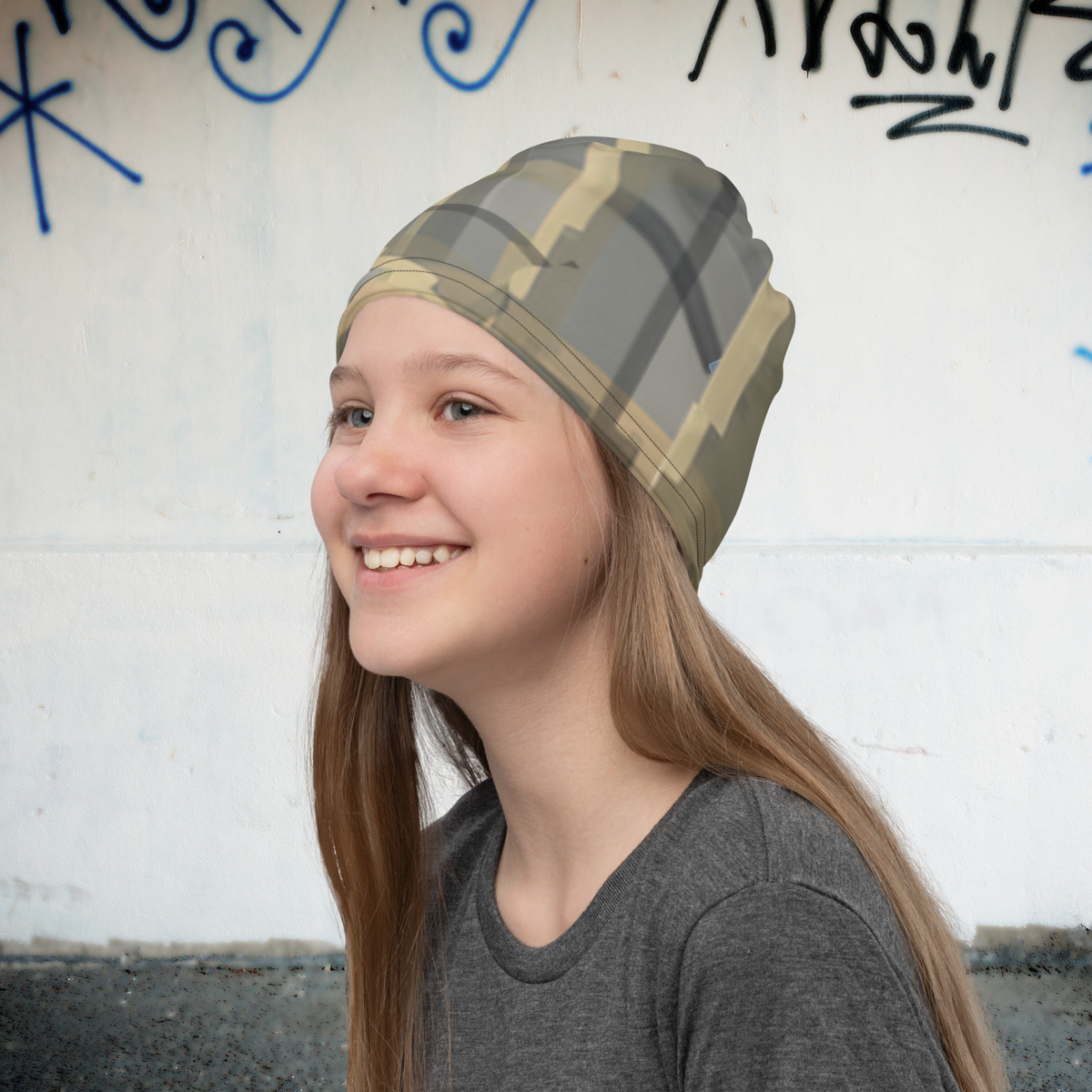 Urban Concrete 7 neck gaiter worn as a beanie beside a graffiti-covered wall.