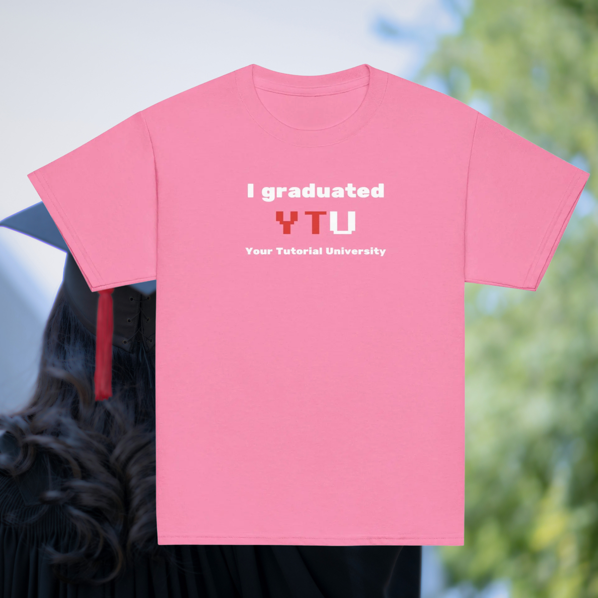 I Graduated YTU kids' T-shirt in pink, front product view against a graduation backdrop.