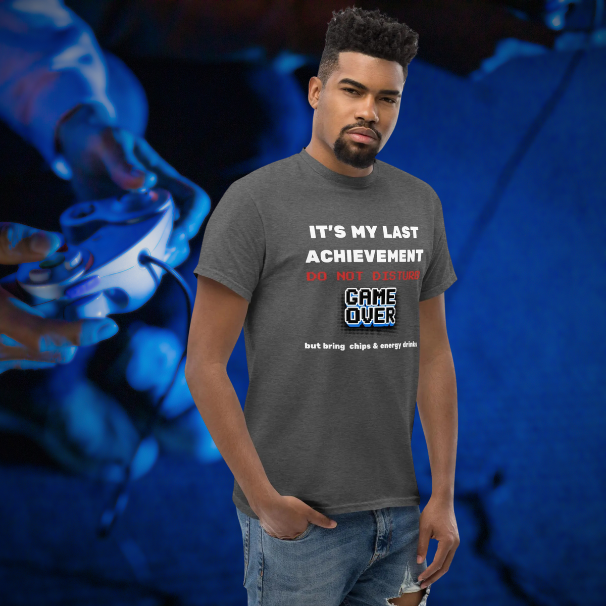 It's My Last Achievement gamer T-shirt in dark heather grey, worn by a model against a blue gaming backdrop.