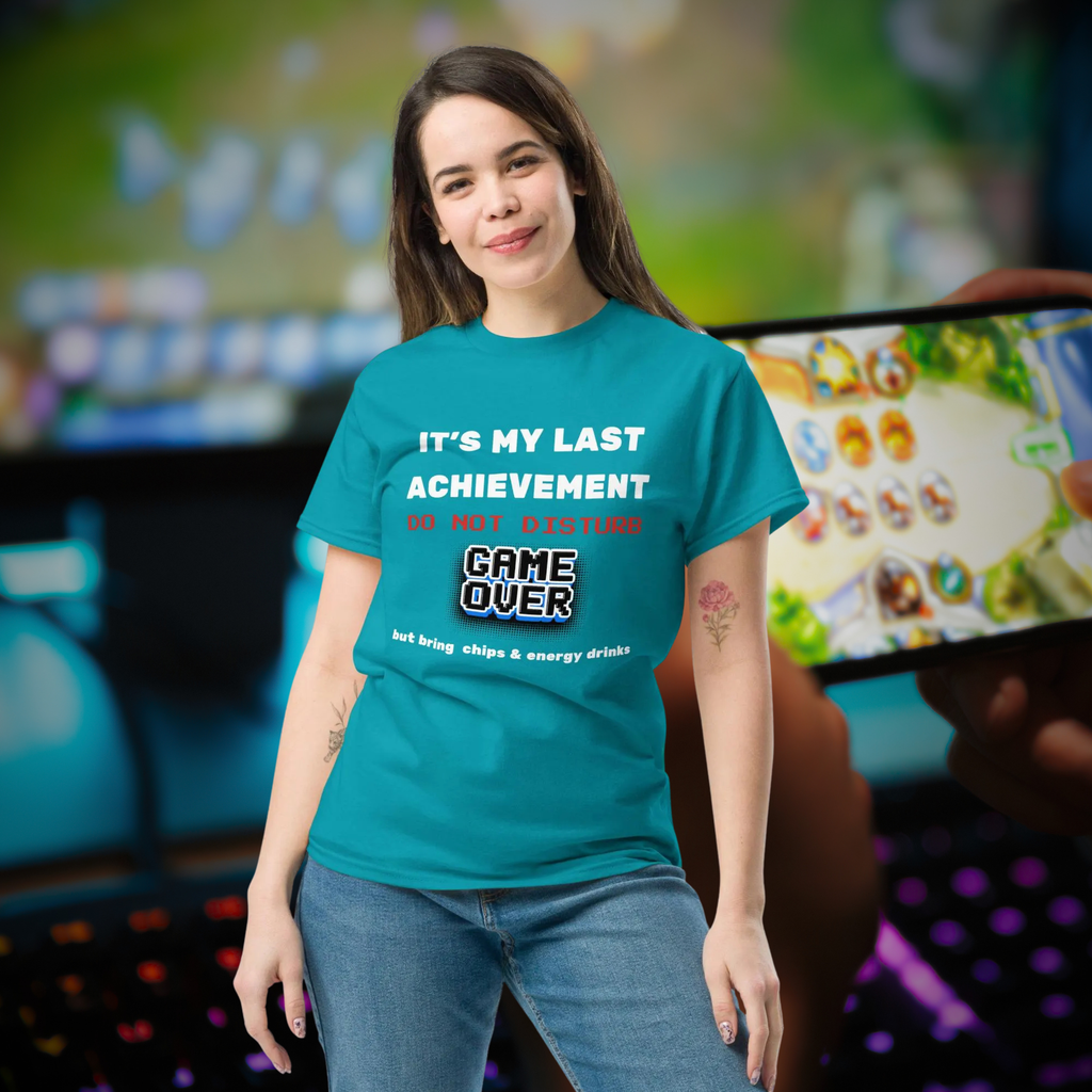 It's My Last Achievement gamer T-shirt in turquoise, worn by a model beside a gaming setup.