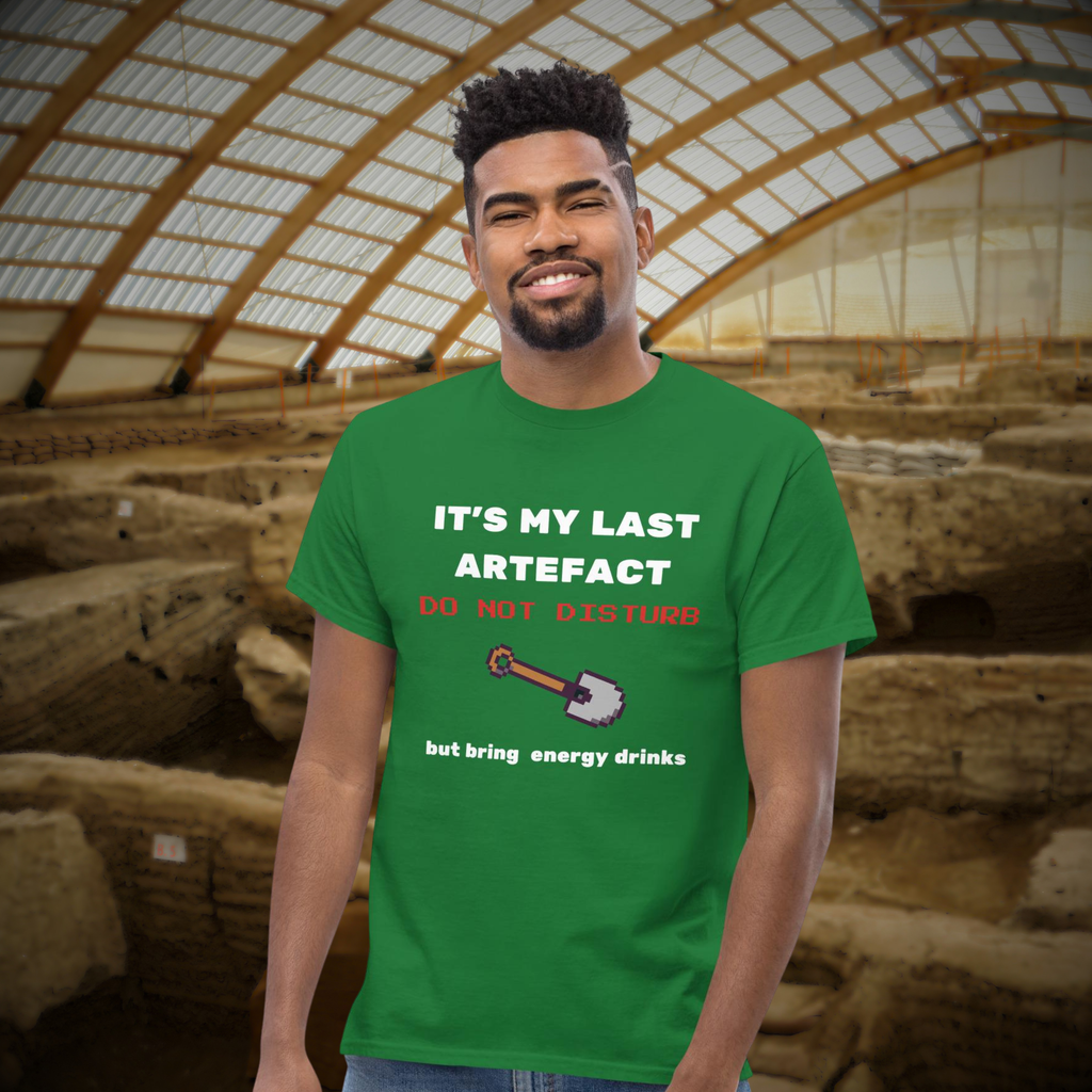 It's My Last Artefact gamer T-shirt in green, worn by a model against an archaeological site backdrop.