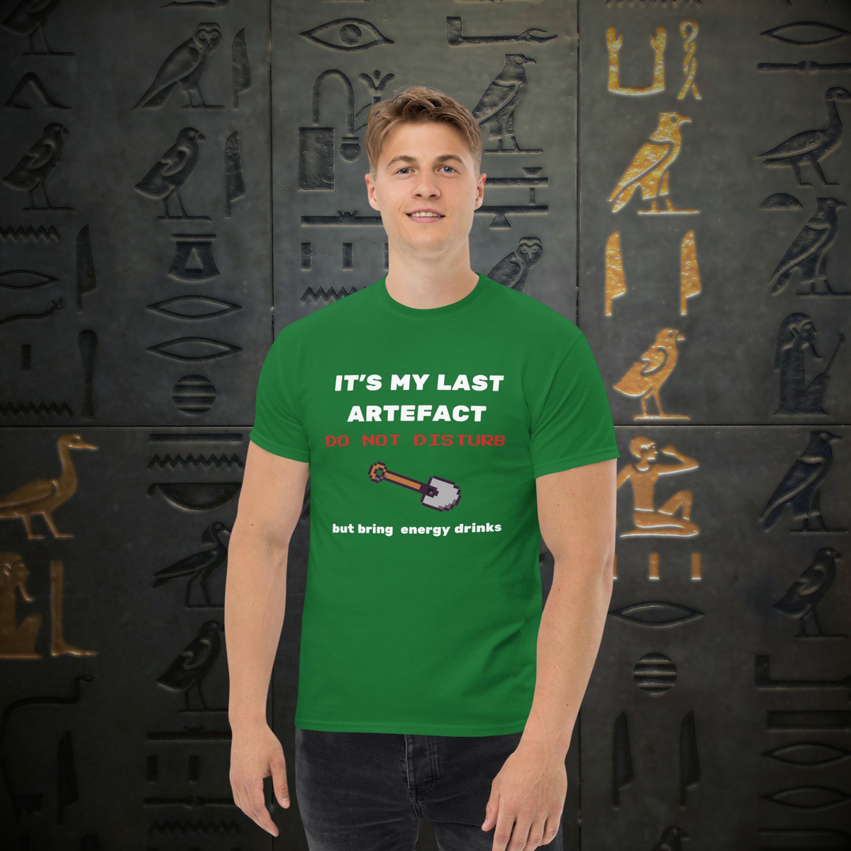It's My Last Artefact gamer T-shirt in green, worn by a model against a hieroglyph-pattern backdrop.