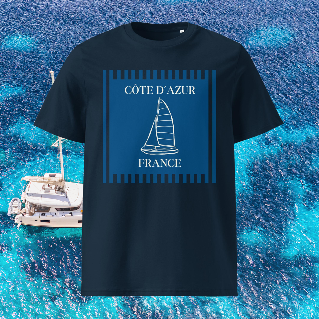 Côte d'Azur sailboat T-shirt in navy, front product view against turquoise water and a sailboat.