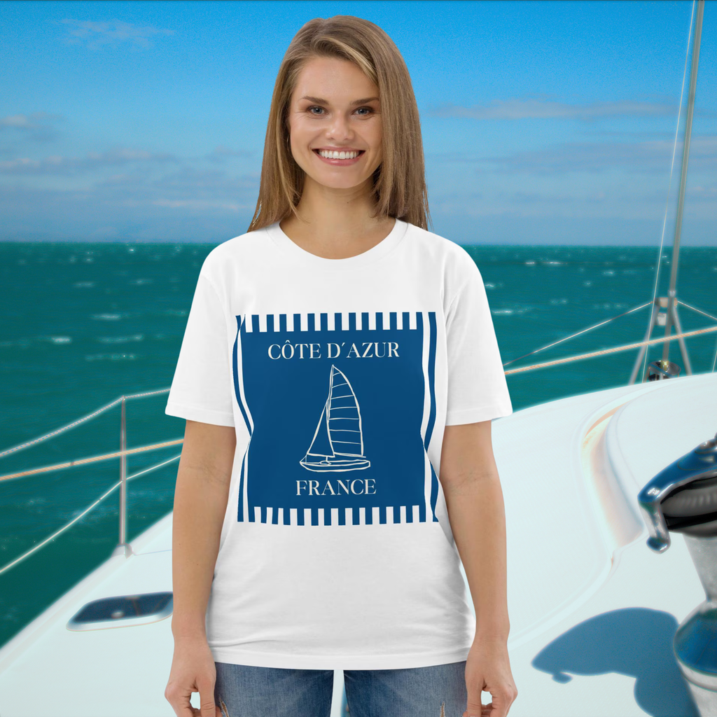 Côte d'Azur sailboat T-shirt in white, worn by a model on a yacht backdrop.
