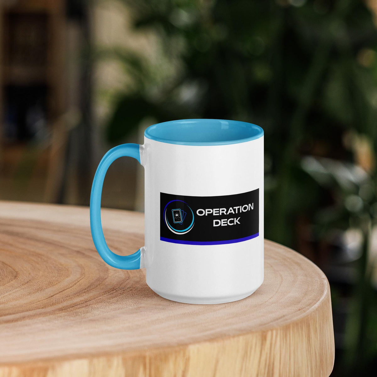 Operation Deck Bien Joué mug logo side on a round wooden table.