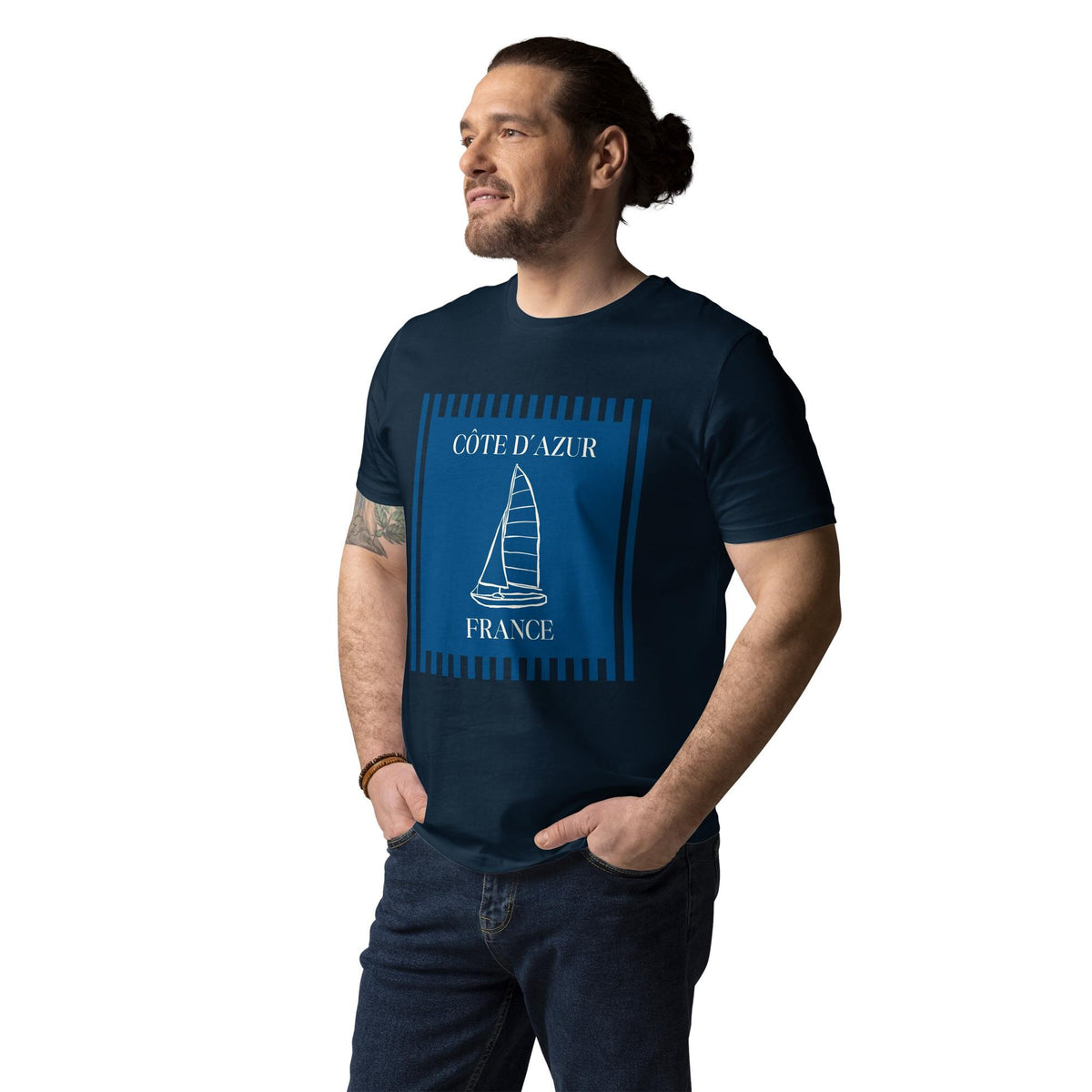 Côte d'Azur sailboat T-shirt in navy, worn by a model with hands in pockets, three-quarter view.