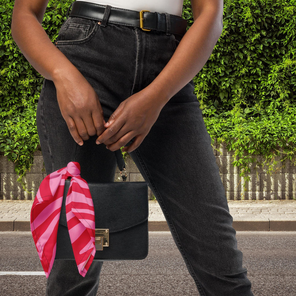 Pink Zebra bandana tied to the handle of a small black handbag.