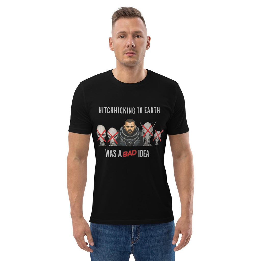 Alien Hitchhiking T-shirt in black, worn by a model with hands in pockets, front view.
