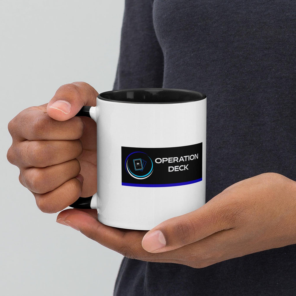 Operation Deck Désagréable mug logo side held in hands against a dark top.