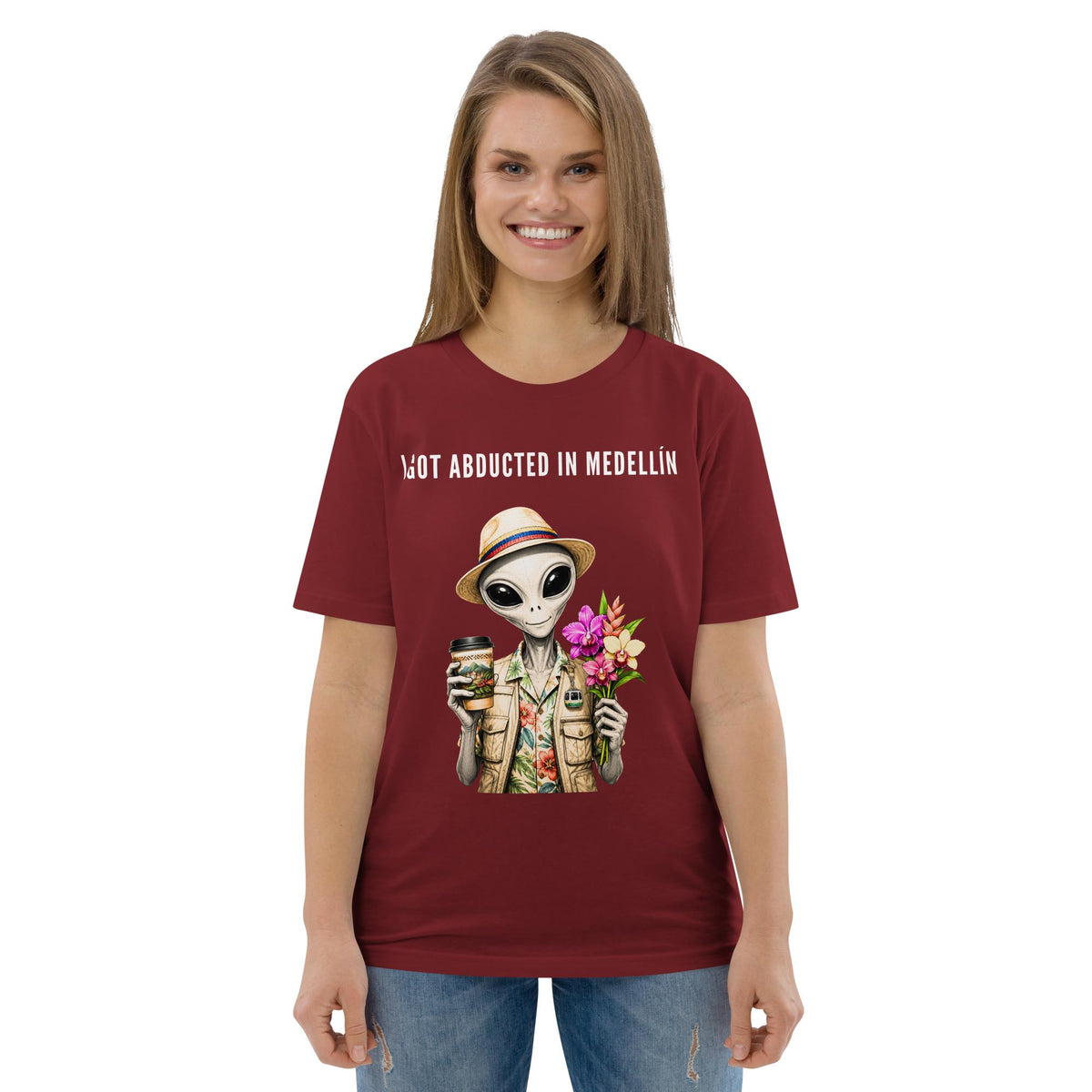 I Got Abducted in Medellin alien T-shirt in burgundy, worn by a model with blue jeans, front view.