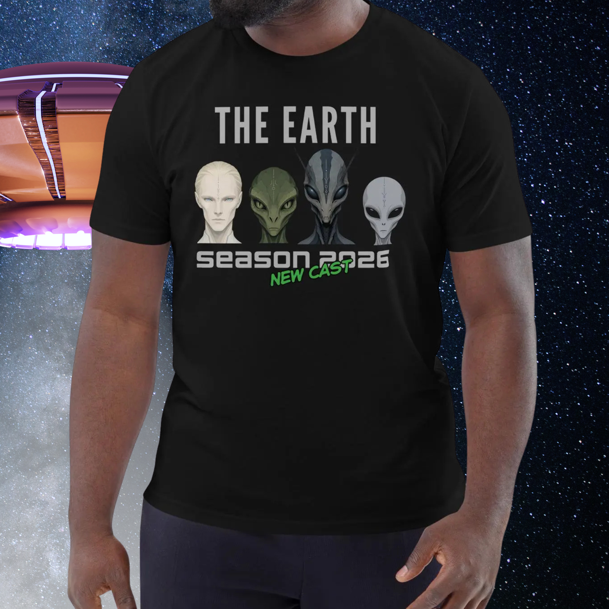 The Earth Season 2026 alien T-shirt in black, torso view against a cosmic UFO backdrop.