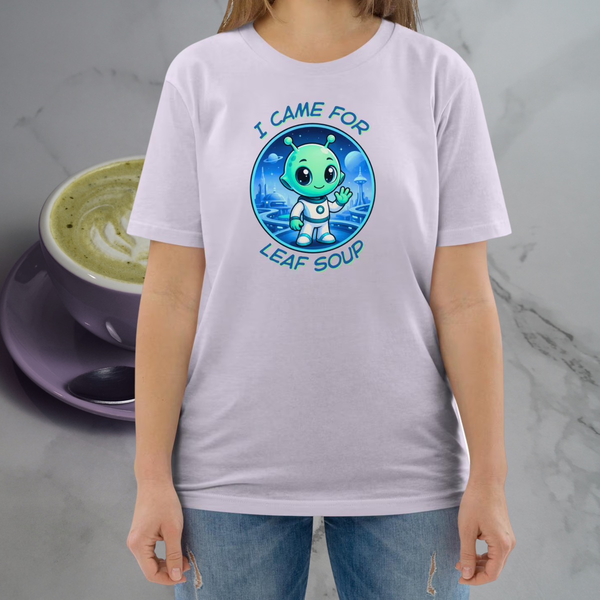 Alien Leaf Soup T-shirt in lavender, torso view beside a green tea cup backdrop.